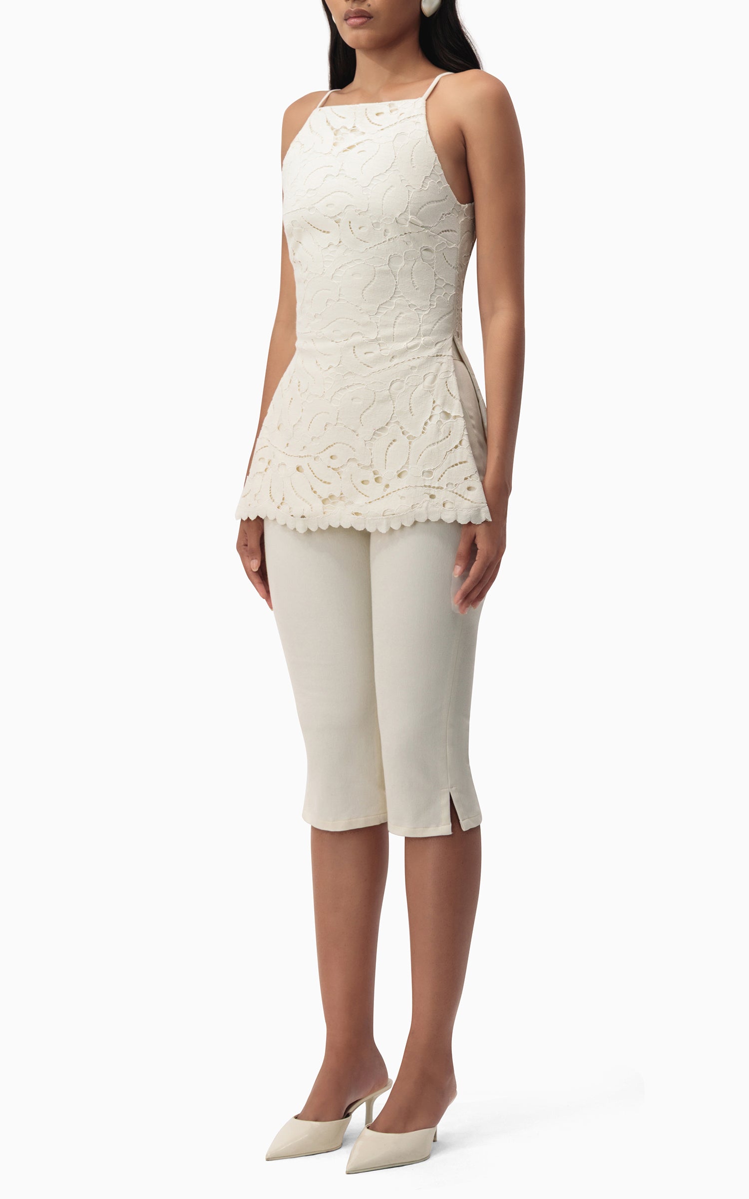 "Side angle of Junie Capri off‑white denim capris showing tailored fit and hem slit"