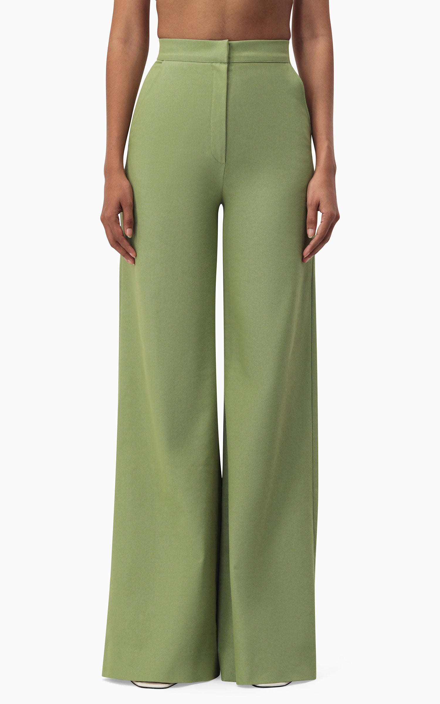 Model wearing Athena Pants in pistachio green – high-waist, wide-leg silhouette with side pockets